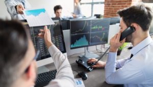 brokerzy rozmawiają przez telefon realizują zlecenia inwestycyjne