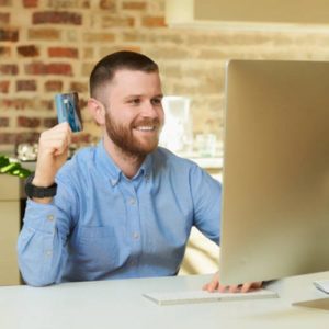 uśmiechnięty inwestor przed komputerem